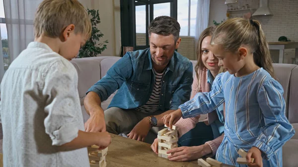 Familie mit Kindern spielt Holzklötze auf Couchtisch — Stockfoto