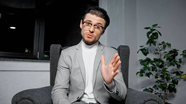 Junger Manager im Anzug redet im Büro vor laufender Kamera — Stockfoto