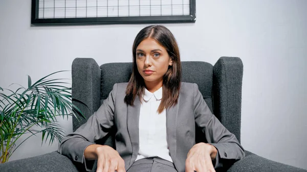 Brünette Manager sitzt auf Sessel in der Nähe von Werk — Stockfoto