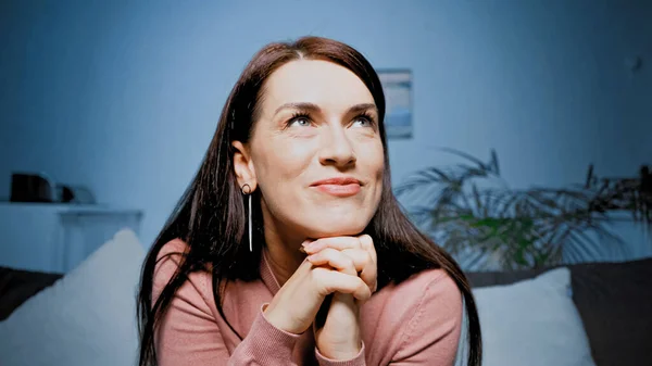 Dreamy woman looking up on couch at home — Stock Photo