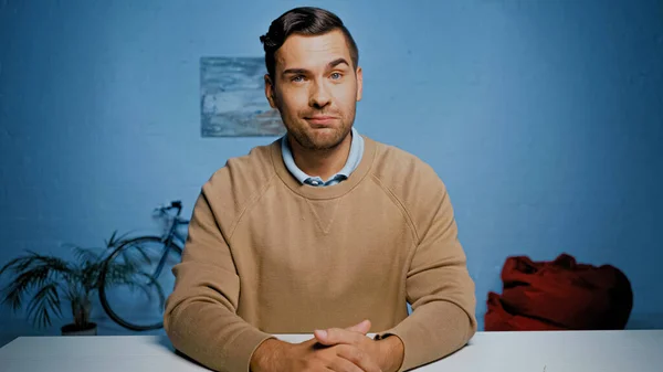 Skeptical man looking at camera at home — Stock Photo