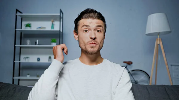 Возбужденный мужчина разговаривает во время видеозвонка дома — стоковое фото