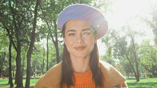 Heureuse femme élégante souriant à la caméra dans le parc d'automne ensoleillé — Photo de stock