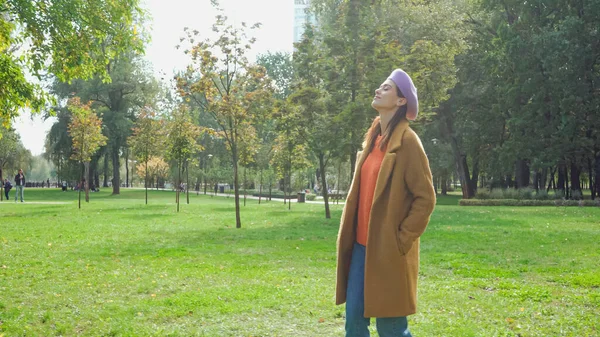 Jeune femme aux yeux fermés profitant de la promenade dans le parc d'automne — Photo de stock