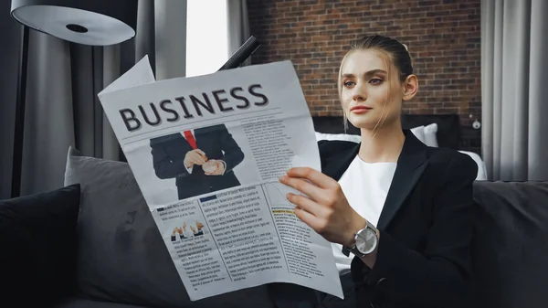Empresária em uso formal ler jornal de negócios no quarto de hotel — Fotografia de Stock