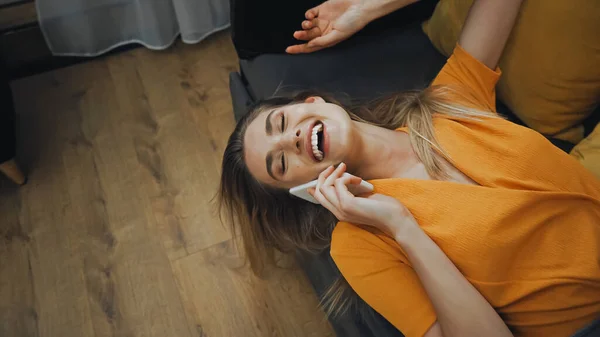 Felice giovane donna ridendo e parlando su smartphone in camera d'albergo — Foto stock