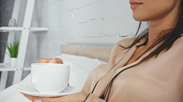 Vista cortada de mulher segurando pires e xícara de café — Fotografia de Stock