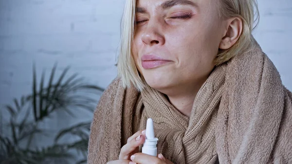Donna malata accigliata con gli occhi chiusi durante l'utilizzo di spray nasale — Foto stock