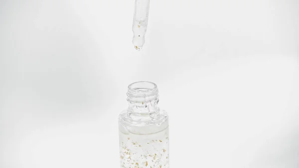 Nahaufnahme einer Pipette über Glasflasche mit ätherischem Öl auf Weiß — Stock Photo