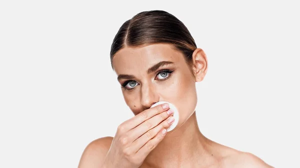 Jeune femme démaquillant sur les lèvres avec coton isolé sur blanc — Photo de stock