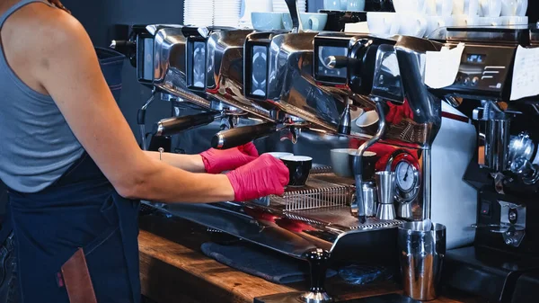 Vista parziale di barista in possesso di tazze vicino alla moderna macchina da caffè in caffetteria — Foto stock