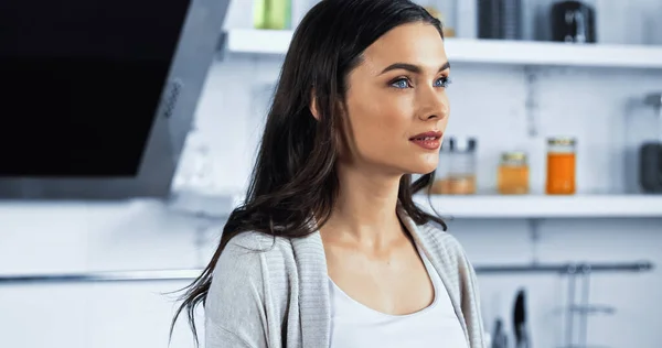 Mujer morena joven mirando hacia otro lado en la cocina — Stock Photo