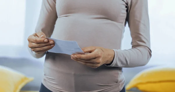 Vista cortada da mulher grávida segurando ultra-som do bebê — Fotografia de Stock