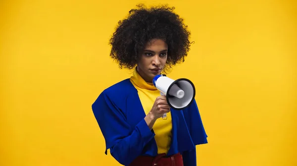 African american woman holding loudspeaker isolated on yellow — Stock Photo