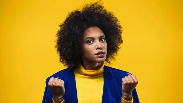 Wütende Afroamerikanerin zeigt Fäuste auf gelbem Grund — Stockfoto
