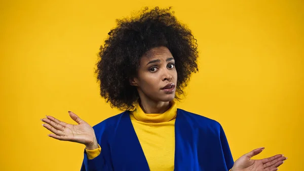 Mujer afroamericana señalando con las manos aisladas en amarillo - foto de stock
