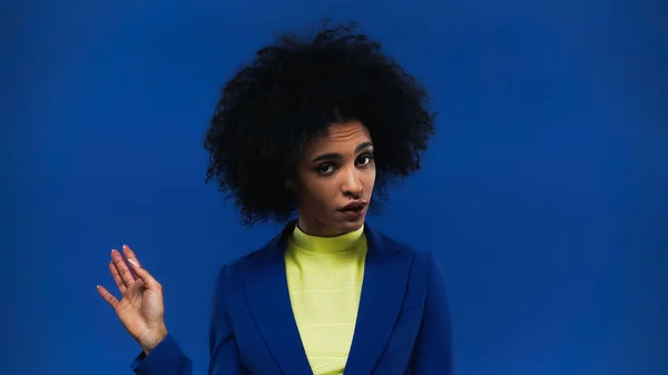 Skeptical african american woman pointing with hand isolated on blue — Stock Photo