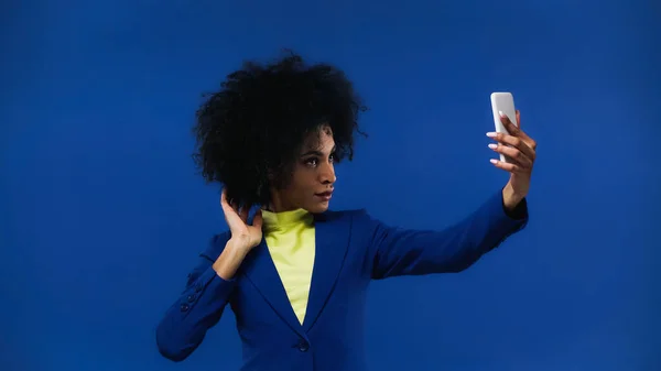 Africano americano mulher tomando selfie com smartphone isolado no azul — Fotografia de Stock