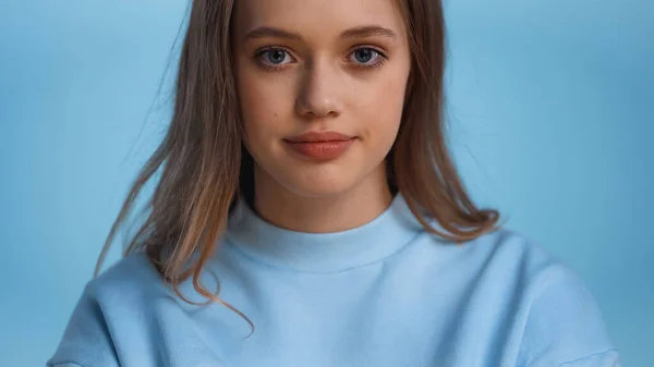 Дівчина-підліток в сорочці дивиться на камеру ізольовано на синьому — стокове фото