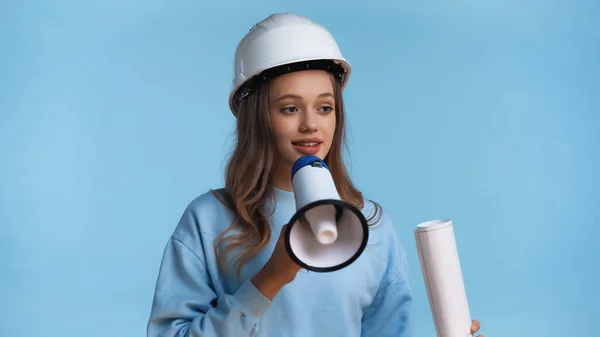 Adolescente in cappello duro con megafono e planimetria arrotolata isolato su blu — Foto stock