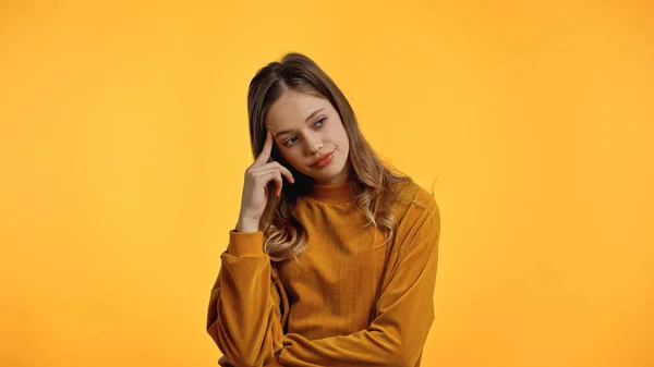 Pensive teenager in sweater looking away isolated on yellow — Stock Photo