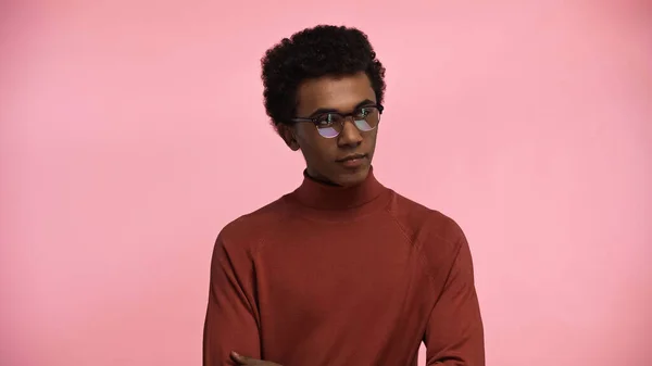 African american teenager in turtleneck sweater and glasses isolated on pink — Stock Photo