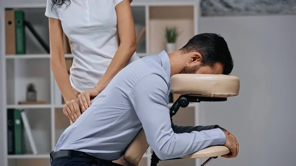 Masseur doing back massage to businessman in office — Stock Photo