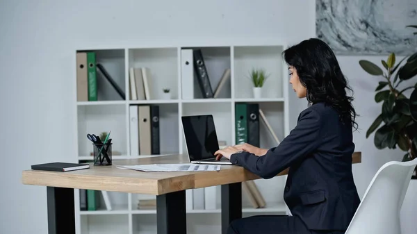 Vista laterale della donna d'affari che utilizza il computer portatile in ufficio — Foto stock