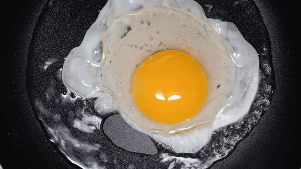 Close up of frying egg on frying pan with oil — Stock Photo