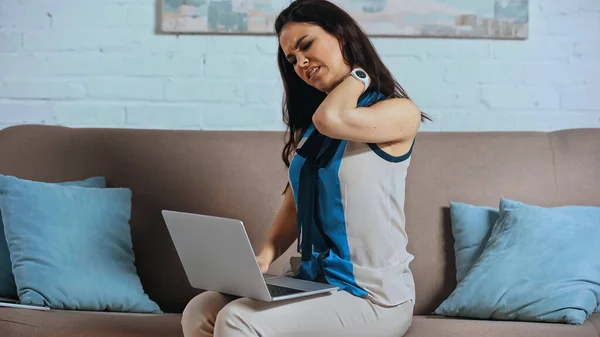 Giovane freelance che soffre di dolore al collo mentre lavora da casa — Foto stock