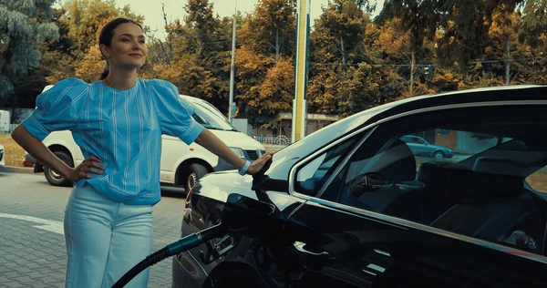 Smiling woman refueling car on gas station — Stock Photo