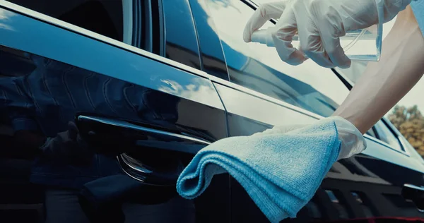 Cropped view of woman in latex gloves spraying disinfectant on rag — Stock Photo