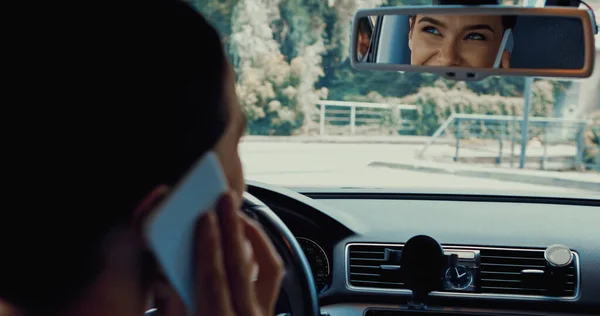 Glückliche Frau, die Auto fährt und mit dem Smartphone spricht — Stockfoto