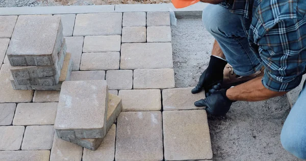 Vista ritagliata dell'uomo che lavora con pietre da pavimentazione in cantiere — Foto stock