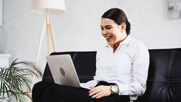 Excited businesswoman laughing while looking at laptop in office — Stock Photo