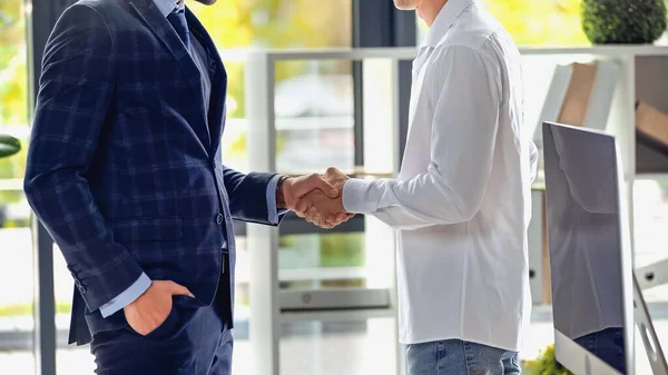 Cropped view of businessmen shaking hands in office — Stock Photo