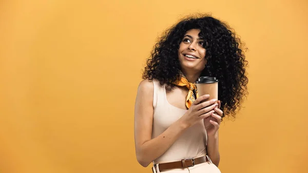 Sorrindo hispânico mulher segurando copo de papel isolado no amarelo — Fotografia de Stock