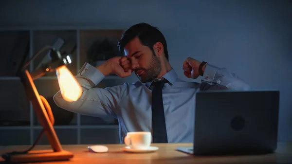 Tired businessman with closed eyes working late in office — Stock Photo