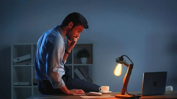 Бизнесмен смотрит на ноутбук во время работы в офисе — стоковое фото
