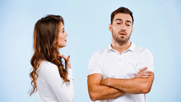 Girlfriend quarrelling with boyfriend standing with crossed arms isolated on blue — Stock Photo