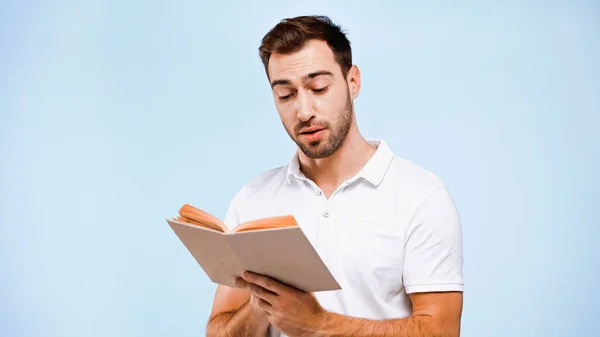 Homem de t-shirt branca leitura livro isolado em azul — Fotografia de Stock