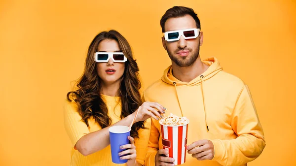 Novio y novia viendo película en gafas 3d aislado en amarillo - foto de stock