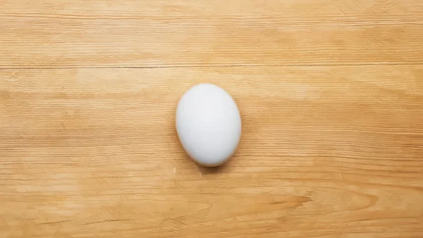 Vista superior del huevo de pollo blanco en la mesa de madera - foto de stock