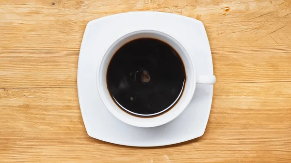 Vista dall'alto del caffè nero in tazza bianca sul tavolo di legno — Foto stock