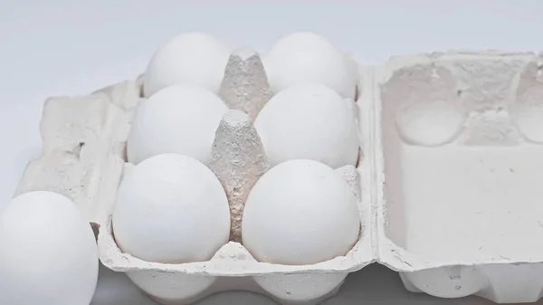 Cardboard package with chicken eggs on white surface — Stock Photo