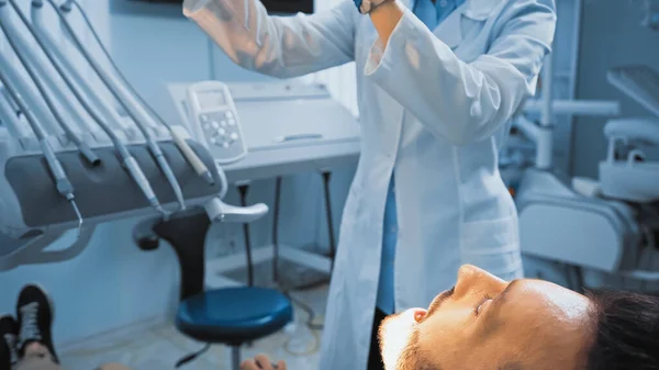 Homem com boca aberta perto de estomatologista na clínica odontológica — Fotografia de Stock