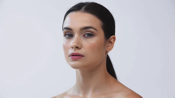 Young, brunette woman with perfect face looking at camera isolated on grey — Stock Photo