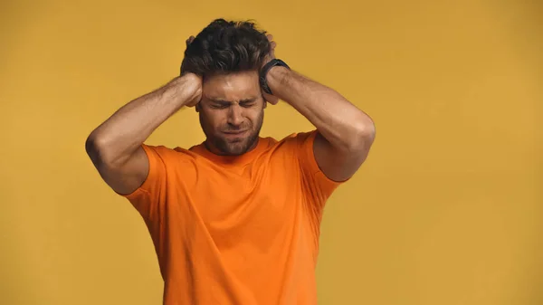 Man touching head while suffering from migraine isolated on yellow — Stock Photo