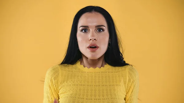 Shocked and scared brunette woman looking at camera isolated on yellow — Stock Photo