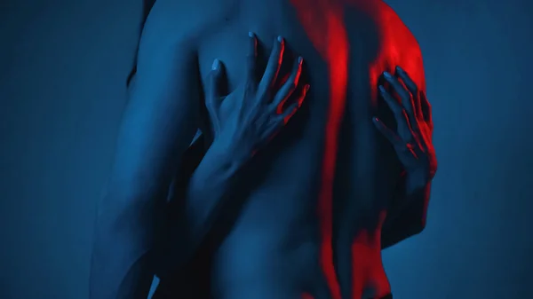 Ausgeschnittene Ansicht einer Frau, die einem hemdlosen Mann auf blauem Grund den Rücken kratzt — Stockfoto
